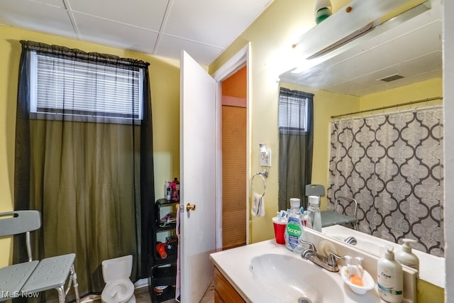 bathroom featuring vanity, a healthy amount of sunlight, and a paneled ceiling