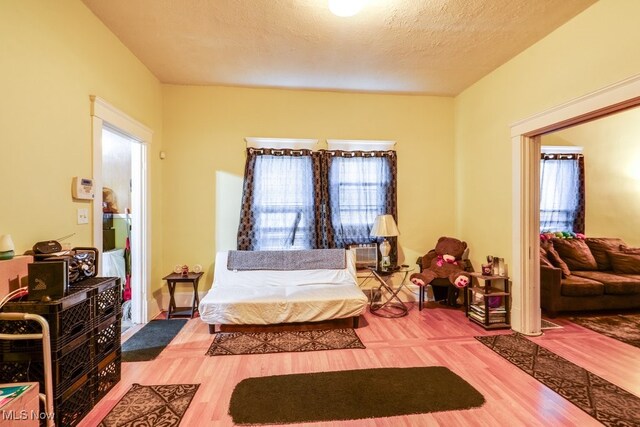 bedroom with a textured ceiling and hardwood / wood-style flooring