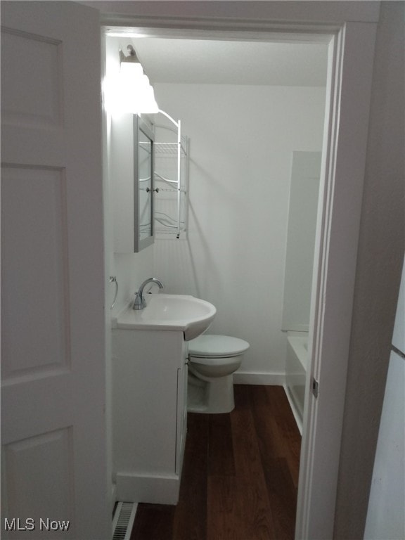 full bathroom featuring hardwood / wood-style flooring, vanity, toilet, and plus walk in shower