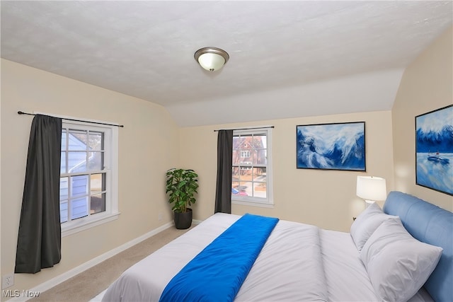 bedroom with carpet floors and vaulted ceiling