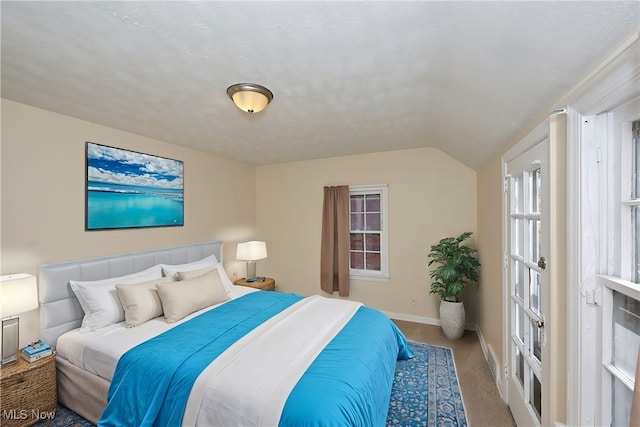 carpeted bedroom with lofted ceiling