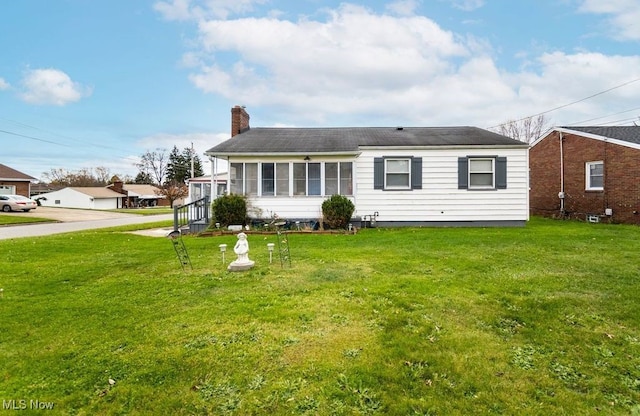 view of front of property with a front lawn and a sunroom