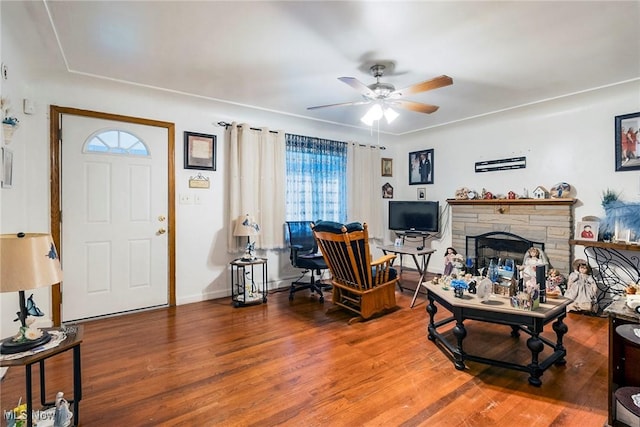 living room with hardwood / wood-style floors, ceiling fan, and a fireplace