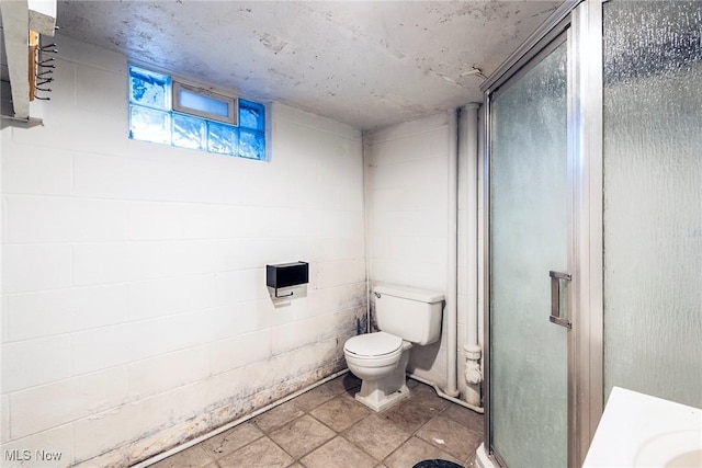 bathroom featuring toilet and a shower with door