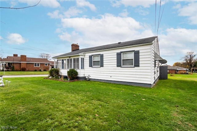 rear view of property featuring a lawn