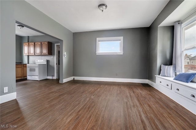 unfurnished living room with a healthy amount of sunlight and dark hardwood / wood-style floors