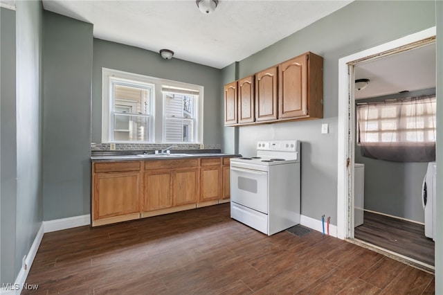 kitchen featuring washer / dryer, white electric range, sink, and dark hardwood / wood-style flooring