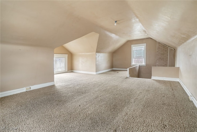 additional living space featuring carpet floors and lofted ceiling