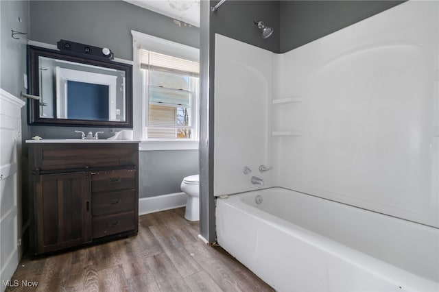 full bathroom featuring toilet, vanity, hardwood / wood-style floors, and shower / washtub combination