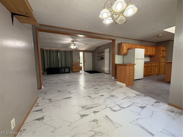 kitchen featuring a textured ceiling, white fridge, and ceiling fan with notable chandelier