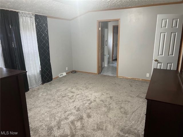 unfurnished room with a textured ceiling and carpet floors