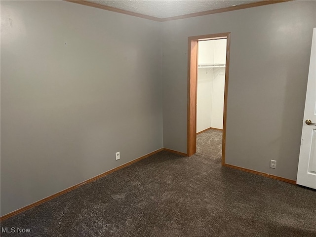 carpeted empty room with a textured ceiling and ornamental molding