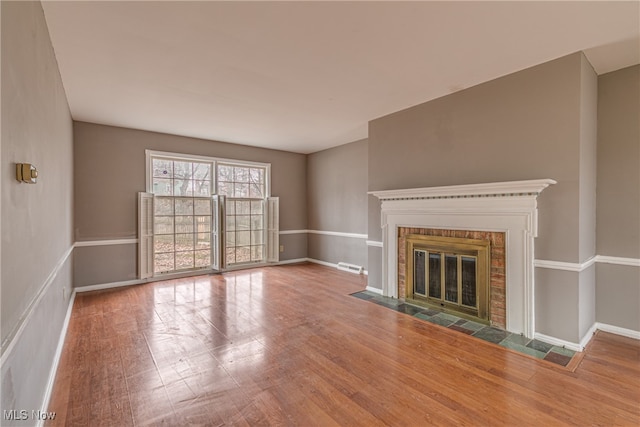 unfurnished living room with hardwood / wood-style floors and a fireplace