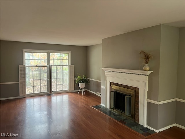 unfurnished living room with a fireplace and dark hardwood / wood-style flooring