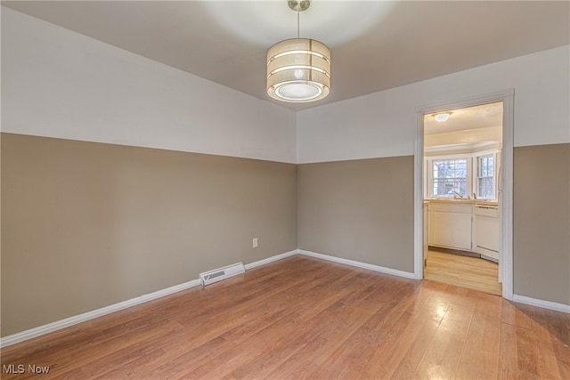 unfurnished room with light hardwood / wood-style flooring and sink