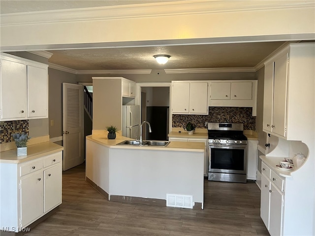 kitchen featuring sink, white refrigerator, stainless steel range oven, and white cabinets