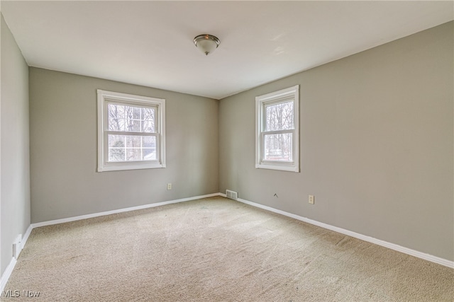 carpeted spare room with a healthy amount of sunlight