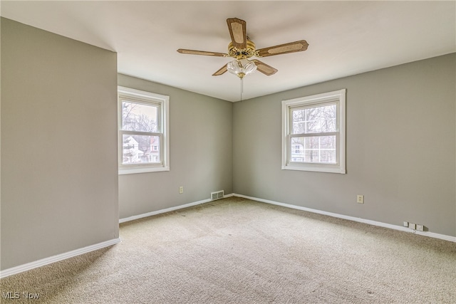 spare room featuring ceiling fan, a healthy amount of sunlight, and carpet