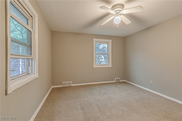 carpeted spare room featuring ceiling fan