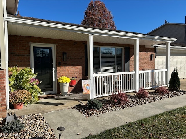 view of exterior entry with a garage and covered porch