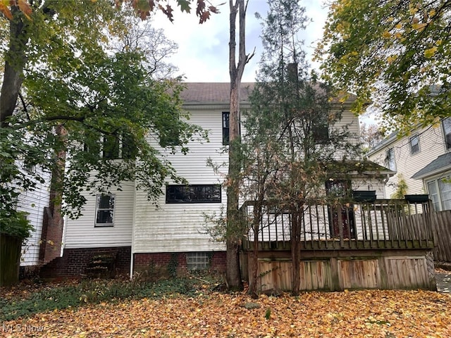 rear view of property featuring a wooden deck