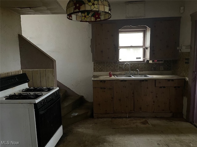 kitchen featuring white gas range, sink, and backsplash