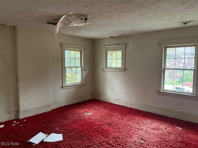 empty room featuring plenty of natural light and a textured ceiling