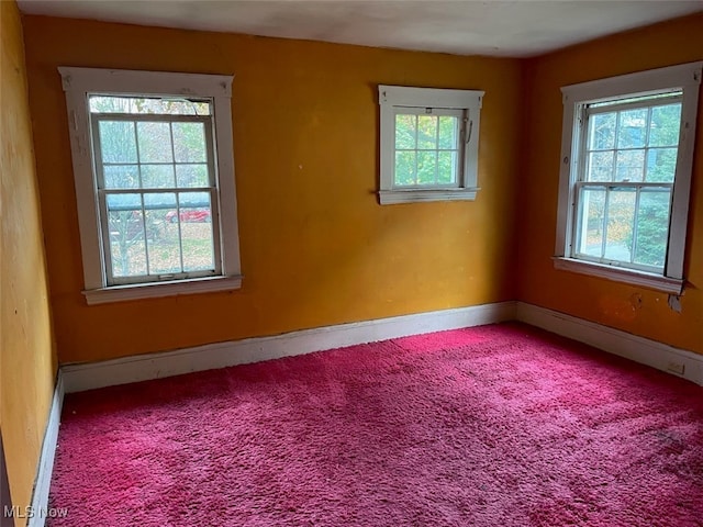 carpeted spare room featuring plenty of natural light