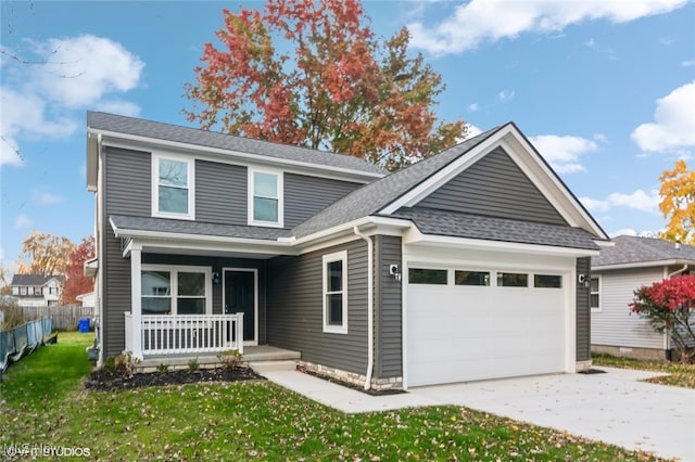 view of front of property with a front lawn, a garage, and covered porch