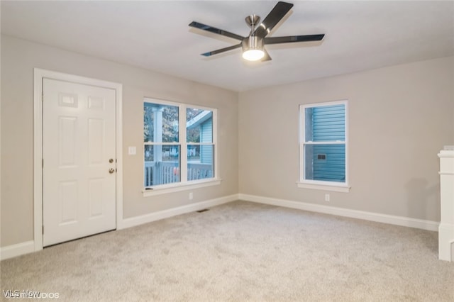 spare room featuring light colored carpet and ceiling fan