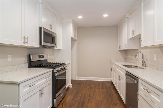 kitchen featuring stainless steel appliances, sink, light stone countertops, white cabinets, and dark hardwood / wood-style flooring