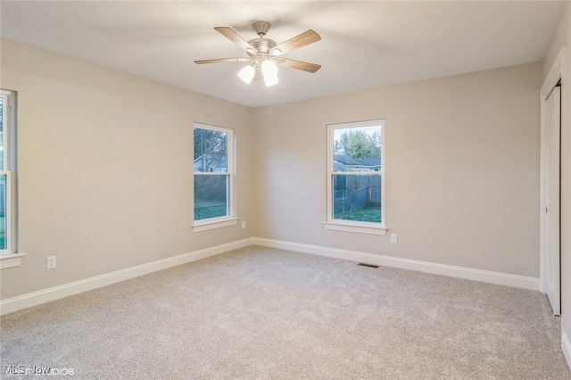 carpeted spare room with ceiling fan