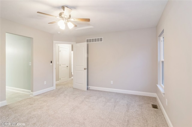 empty room featuring light colored carpet and ceiling fan