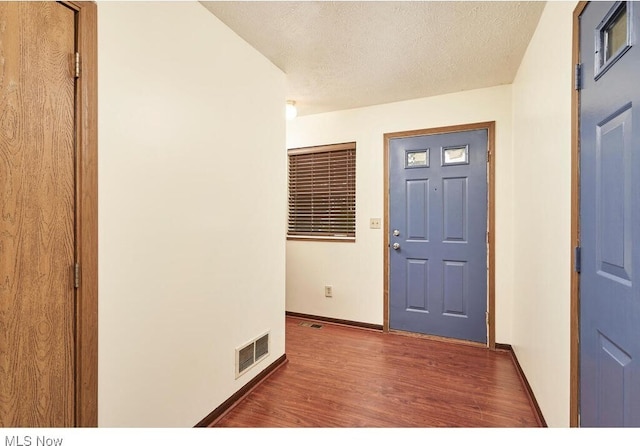 entrance foyer with dark hardwood / wood-style flooring and a textured ceiling