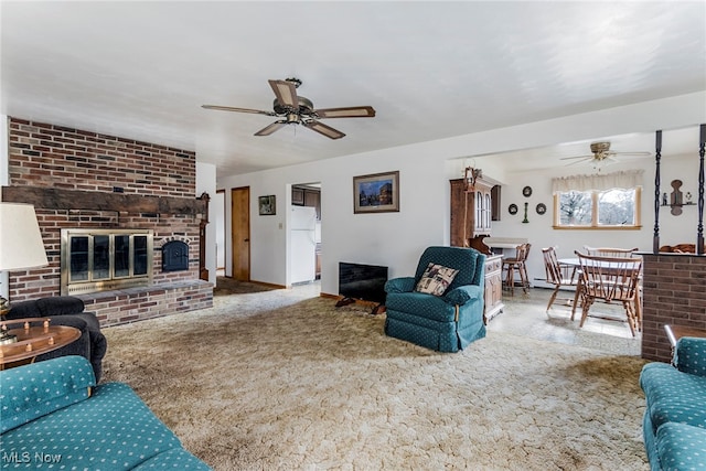 living room with a fireplace, ceiling fan, and carpet flooring