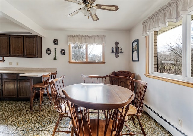 dining area featuring a baseboard heating unit and ceiling fan