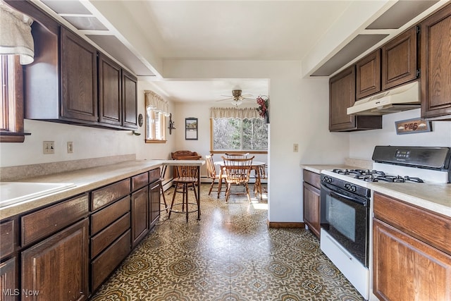 kitchen with dark brown cabinets, ceiling fan, sink, and white range with gas cooktop