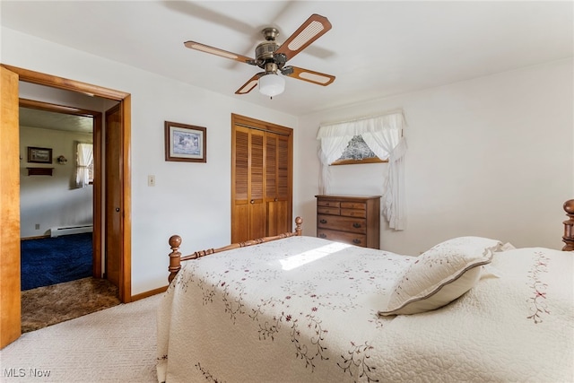 carpeted bedroom featuring a closet, baseboard heating, and ceiling fan