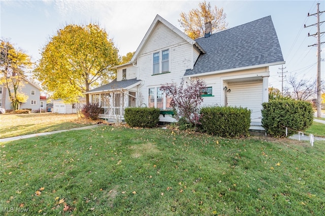 view of property with a sunroom and a front lawn