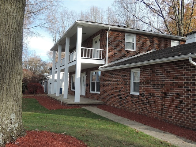 view of property exterior featuring a yard and a balcony