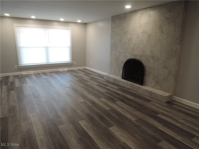 unfurnished living room featuring a fireplace and dark hardwood / wood-style flooring