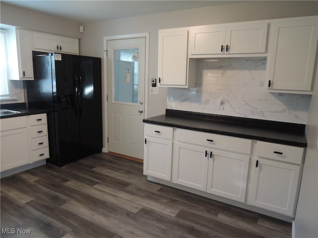 kitchen with white cabinets, black refrigerator with ice dispenser, dark wood-type flooring, and backsplash