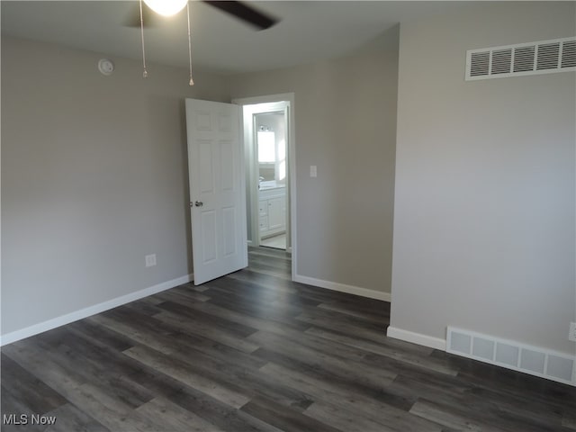 empty room featuring dark hardwood / wood-style flooring and ceiling fan