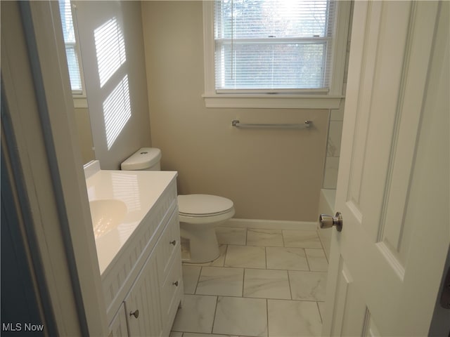 bathroom with toilet, vanity, and a tub