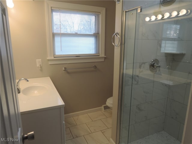 bathroom featuring walk in shower, vanity, toilet, and tile patterned floors