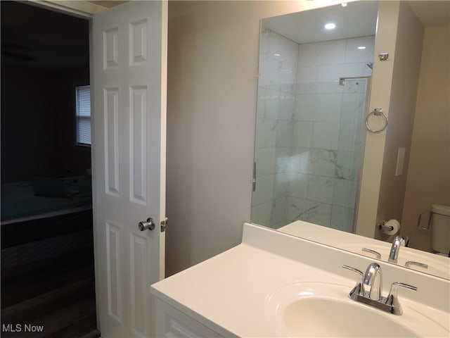 bathroom with toilet, sink, and tiled shower