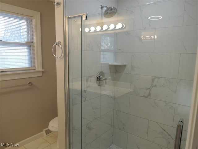 bathroom featuring walk in shower, tile patterned floors, and toilet