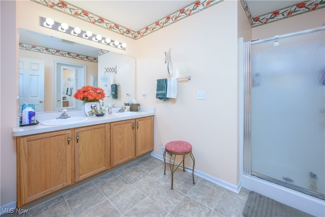 bathroom with a sink, a stall shower, and double vanity