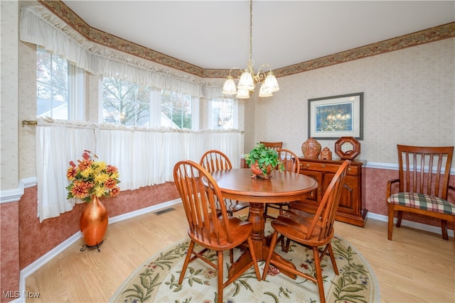 dining area with visible vents, wallpapered walls, baseboards, a chandelier, and light wood-style flooring