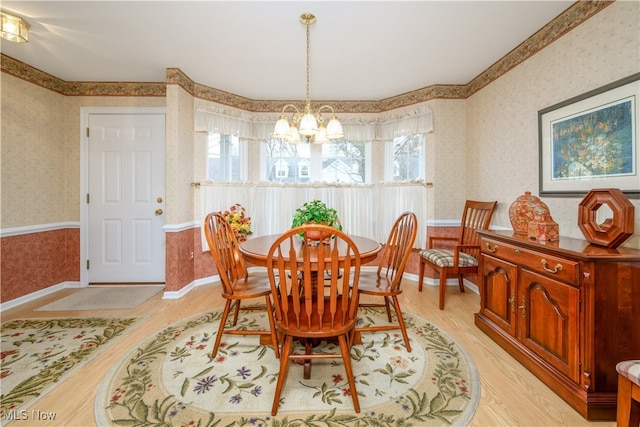 dining space featuring baseboards, a notable chandelier, light wood-style flooring, and wallpapered walls